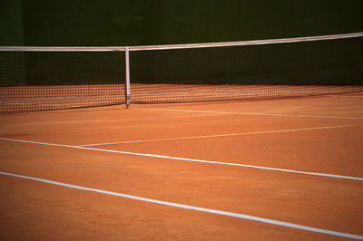 Empty tennis court during sunny day