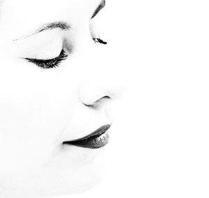 Close-up of woman looking away against white background