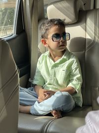 Full length of boy sitting in car