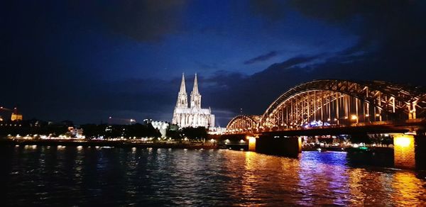 Illuminated bridge over river at night