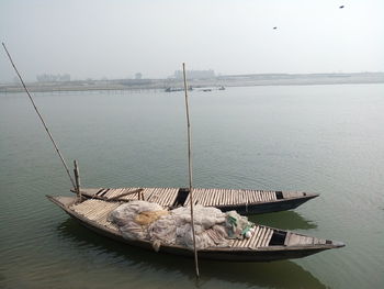 Boat moored on sea against sky