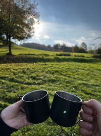 Cropped hand of persons holding cups