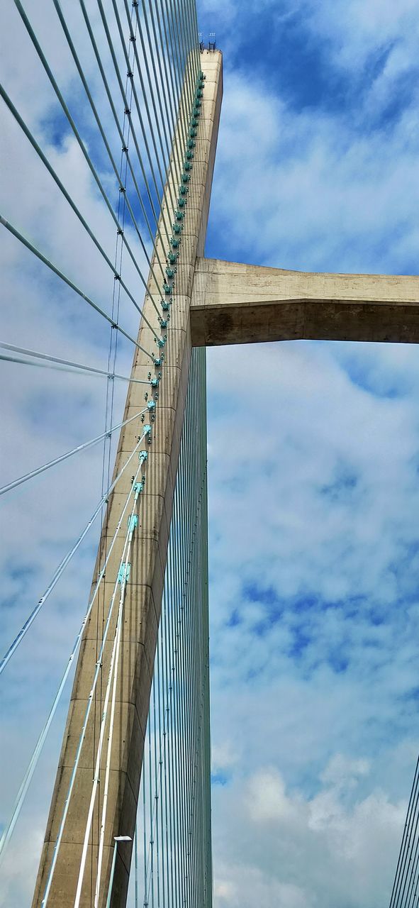 cloud, sky, cable-stayed bridge, bridge, architecture, built structure, suspension bridge, transportation, blue, city, engineering, nature, skyscraper, low angle view, cable, steel cable, building exterior, day, travel, travel destinations, outdoors, mast, line, landmark, road, water