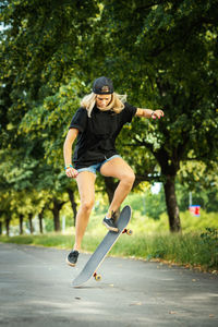 Woman performing stunt on skateboard at park