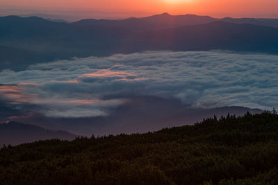 Scenic view of silhouette mountains against sky at sunset