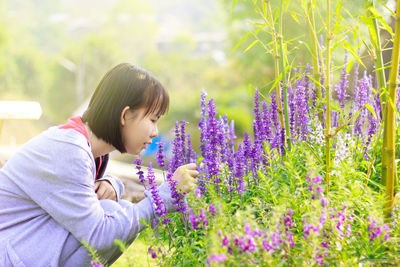 Side view of woman on purple flowering plants