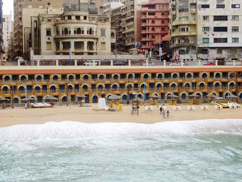 Group of people in sea against buildings in city