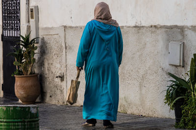 Rear view of woman walking against building