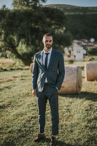 Portrait of young man standing on field