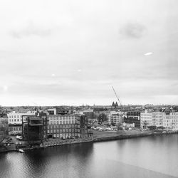 View of cityscape by sea against sky