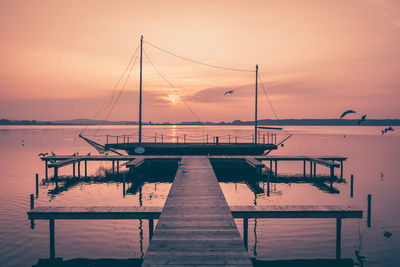 Pier on sea at sunset