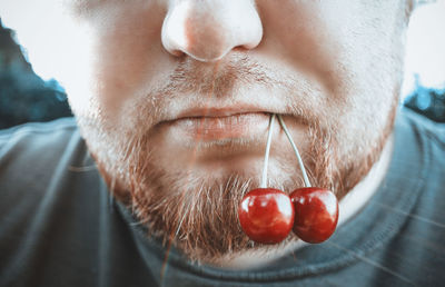 Close-up of man with cherry in mouth