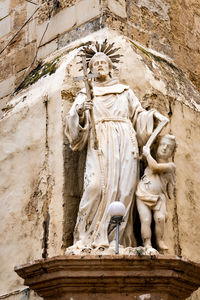 Low angle view of angel statue against temple