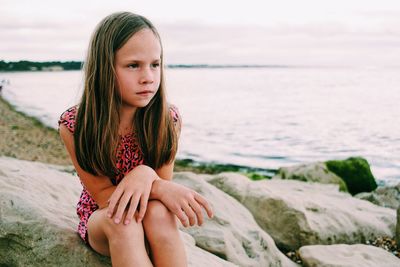 Girl sitting on rock at beach