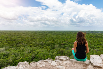 Rear view of woman looking at landscape against sky