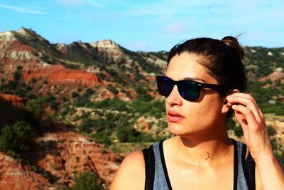 Young woman standing against mountains