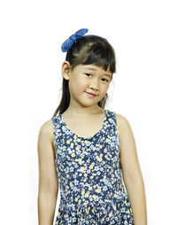 Portrait of smiling girl standing against white background