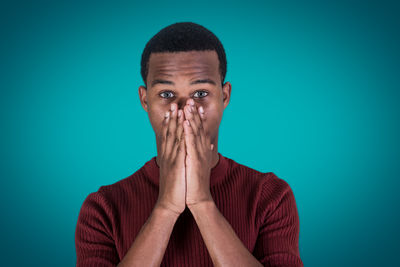 Portrait of young man against blue background