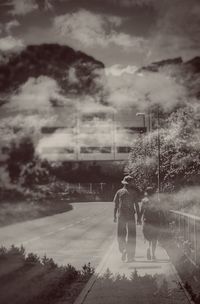 Rear view of woman walking on road in city