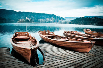 Boats moored on lake against sky