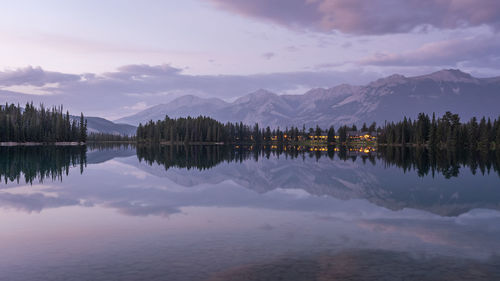 Colourful sunset on mirrorlike lake with mountains in backdrop, jasper national park, canada