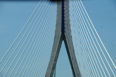 Low angle view of suspension bridge against clear blue sky