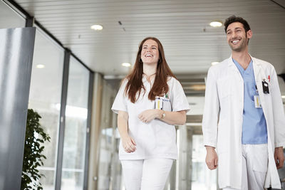 Portrait of smiling young woman standing in corridor