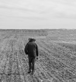 Rear view of man walking on field