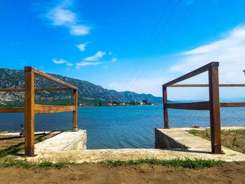 Bridge over sea against blue sky