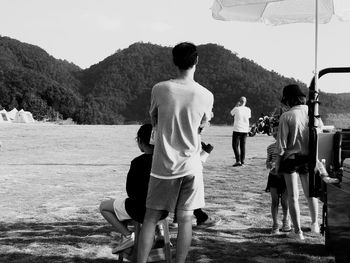 Rear view of couple walking on field