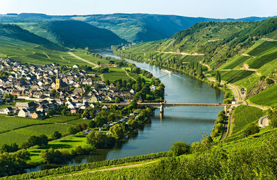 High angle view of river by mountains against sky