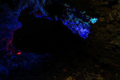 View of blue sea and rock formations at night