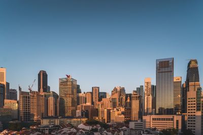Buildings in city against clear sky