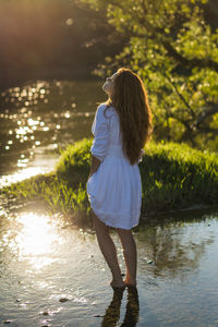 Rear view of woman standing in lake