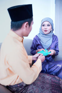 Husband and wife sharing gift during the eid festival