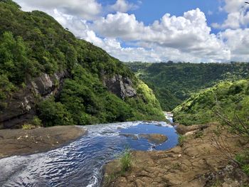 Scenic view of river amidst mountains against sky