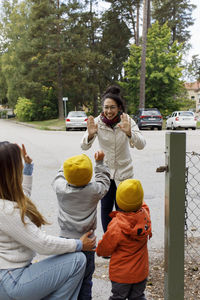 Smiling woman greeting children