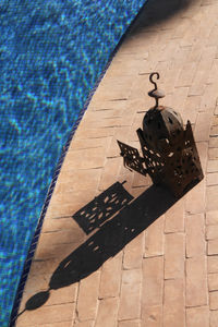 High angle view of lantern by swimming pool on sunny day