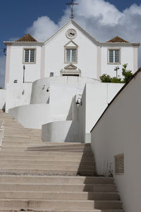 Low angle view of staircase by building against sky