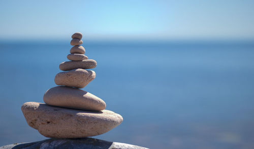 Close-up of stack of pebbles against calm sea