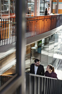 High angle view of business colleagues talking while standing on steps at office