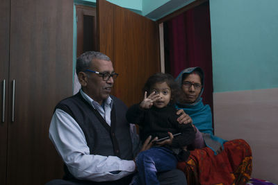 Full length of father with son sitting at home