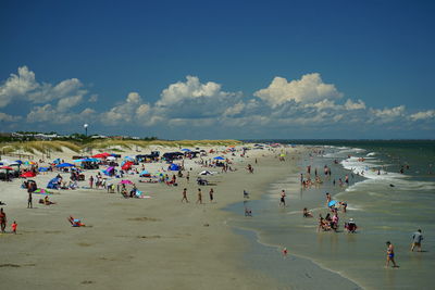 People at beach against sky