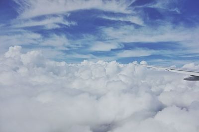 Aerial view of snow covered landscape against cloudy sky