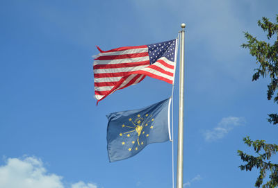 Low angle view of flag flags against blue sky