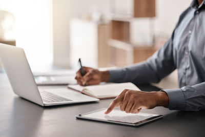 Midsection of businessman using laptop at office