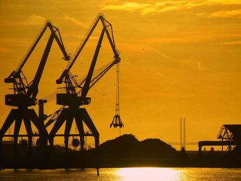 Silhouette of pier over sea against sky during sunset