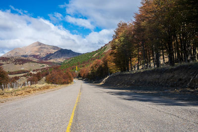 Road amidst trees against sky