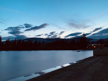 Scenic view of lake by mountains against sky