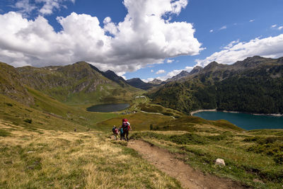 People riding motorcycle on mountain against sky